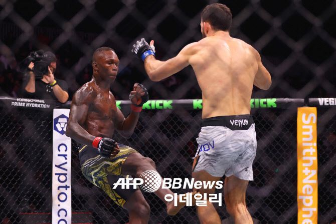 전 UFC 미들급 챔피언 이스라엘 아데산야(왼쪽)가 나수르딘 이마보프의 펀치를 맞고 쓰러지고 있다. 사진=AFPBBNews