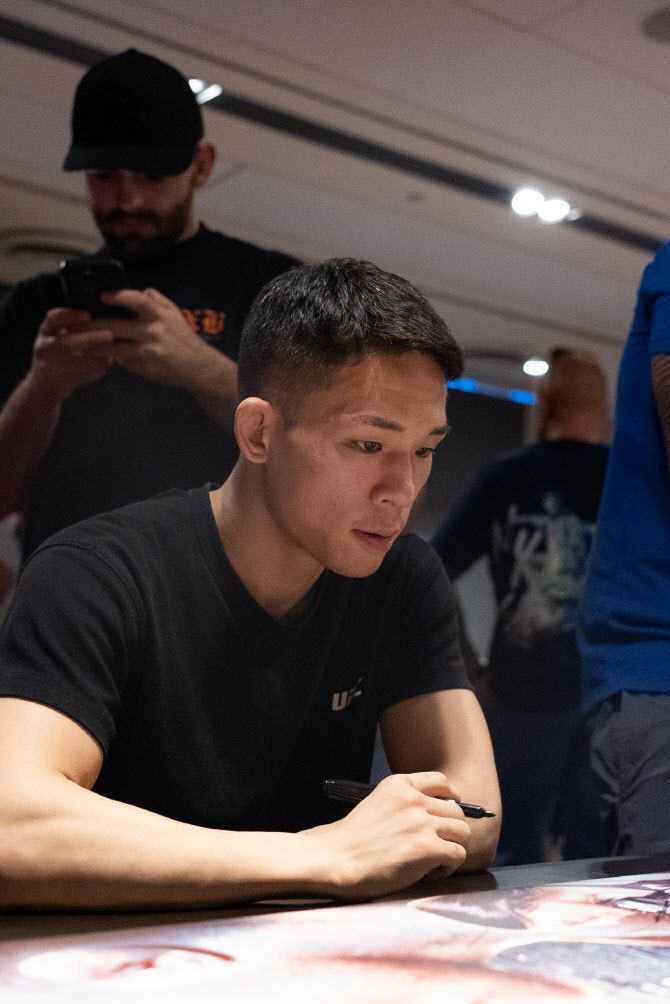 호주에서 열리는 UFC 경기를 앞둔 박현성이 자신의 얼굴이 담긴 대회 포스터에 사인을 하고 있다. 사진=UFC