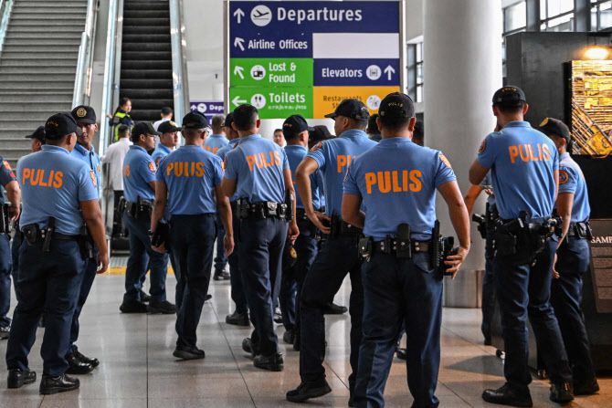 11일(현지시간) 마닐라 국제공항에서 경찰들이 로드리고 두테르테 전 필리핀 대통령의 도착을 기다리며 모여 있다. (사진=AFP)