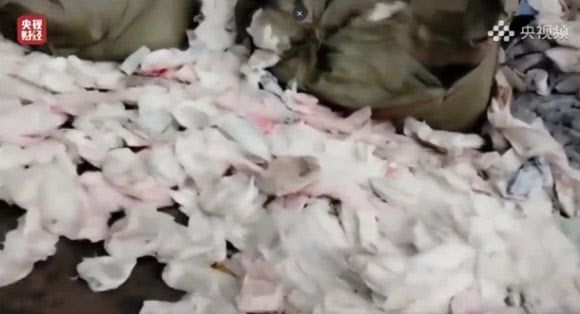 중국 업체 창고에 지저분하게 관리된 생리대와 기저귀 등이 널브러져 있다. (출처=CCTV 캡처)