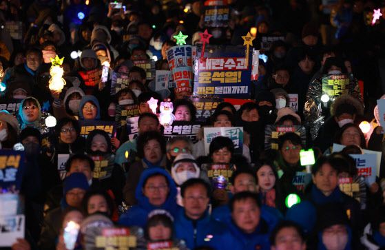 지난 19일 서울 종로구 동십자각 앞에서 열린 윤석열 대통령 탄핵 촉구 집회에서 참가자들이 손 피켓을 들고 있다.(사진=뉴시스)