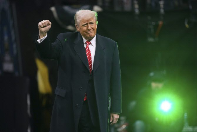 도널드 트럼프 미국 대통령이 지난 22일(현지시간) 미국 펜실베이니아주에서 열린 미국대학스포츠협회(NCAA) 주최 레슬링선수권대회 관전 중 관중들의 환호에 화답하고 있다. (사진=AP)