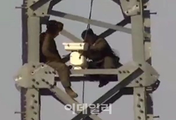 철거하지 않은 DMZ 내 경의선 34번 송전탑에 감시카메라를 설치하고 있는 북한군 (사진=합참)