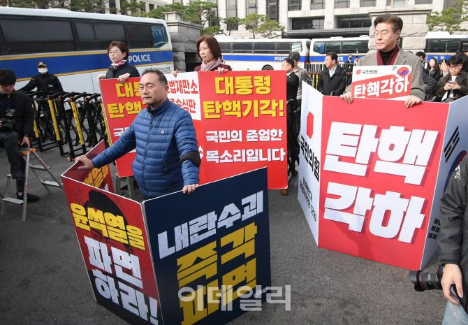 지난 24일 오전 서울 종로구 재동 헌법재판소 앞에서 김정재(뒤쪽 왼쪽부터), 김미애 국민의힘 의원이 윤석열 대통령 탄핵에 반대하는 피켓을 들고 있다. 앞쪽은 윤 대통령 탄핵을 촉구하는 김원이 더불어민주당 의원. (사진=이데일리 이영훈 기자)