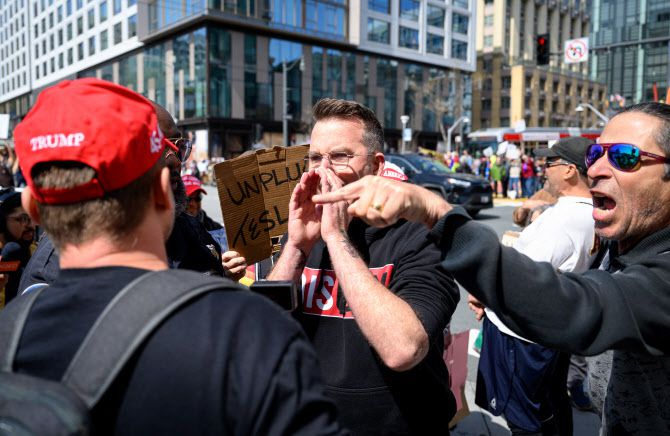 29일(현지시간) 미국 캘리포니아주 샌프란시스코의 한 테슬라 매장 밖에서 열린 ‘테슬라 테이크다운’ 시위에서 참가자들이 친트럼프 모자를 쓴 남성을 비난하고 있다. (사진=AFP)