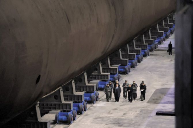 북한은 지난 8일 김정은 국무위원장이 조선소를 찾아 건조 중인 ‘핵동력 전략유도탄 잠수함’을 시찰했다며 현장 사진을 공개했다. 북한이 공개한 사진을 보면 김정은은 건조 중인 잠수함 옆을 걸으며 참모들의 보고를 받고 있다. 김정은의 방문 시점과 장소는 공개하지 않았다. (사진=연합뉴스)