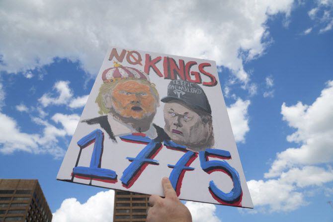 5일(현지시간) 미국 조지아주 애틀랜타에서 열린 전국적인 트럼프 반대 ‘손 떼’ 시위에서 한 사람이 팻말을 들고 있다. (사진=로이터)