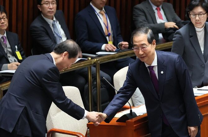 한덕수 국무총리가 2023년 11월 9일 국회에서 열린 예산결산특별위원회 전체회의에서 이완규 법제처장과 악수하고 있다. (사진=연합뉴스)