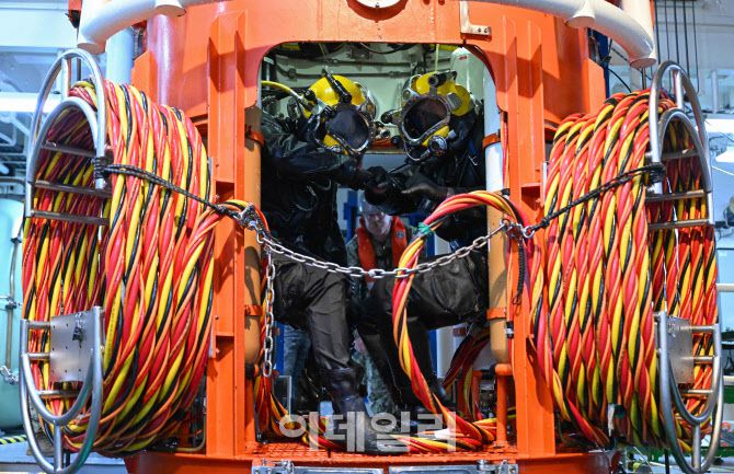 9일 수상함구조함 광양함에서 진행된 한미 해군 연합 구조전 훈련에서 한미 구조부대 장병들이 잠수사 수중 이송장비인 Wet-Bell에 탑승해 수중으로 입수하기 전 임무수행의지를 다지고 있다. (사진=해군)