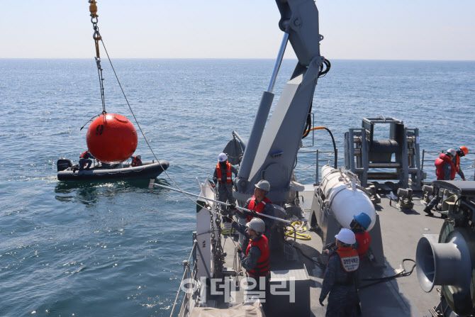 연합 기뢰전 훈련에 참가한 소해함 홍성함 장병들이 기계식 소해구(기뢰제거 장비)로 절단한 훈련용 계류기뢰 회수를 위해 함미 갑판 크레인을 이용, 기뢰를 인양하고 있다. (사진=해군)