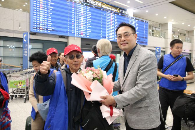 고려인 동포 TSOY NIKOLAY씨(왼쪽)가 92년 만의 첫 모국 방문을 기념해 이경민 이스타항공 커머셜 본부장 및 임직원들의 환영 인사를 받고 있다. (사진=이스타항공)