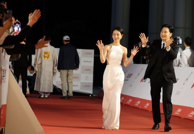 제26회 전주국제영화제가 개막한 30일, 전북 전주시 덕진구 한국소리문화의전당에서 열린 레드카펫 행사에서 개막식 사회를 맡은 배우 김신록(왼쪽)과 서현우가 팬들을 향해 손을 흔들고 있다.(사진=연합뉴스)