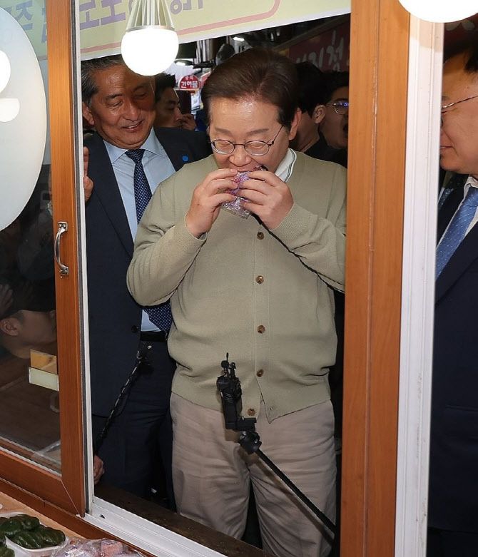 더불어민주당 이재명 대선 후보가 ‘골목골목 경청투어:국토종주편’에 나선 6일 충북 영동군 영동전통시장의 한 떡집에서 떡을 사먹고 있다.(사진=연합뉴스)