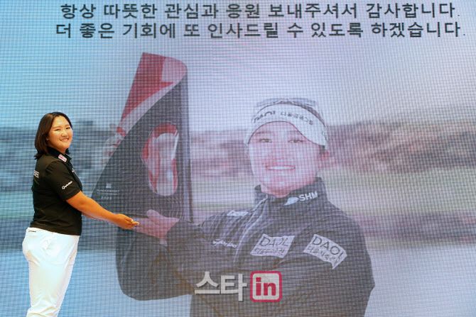 유해란이 자신의 사진 앞에서 미소를 지으며 기념 촬영을 하고 있다.(사진=이데일리 골프in 조원범 기자)