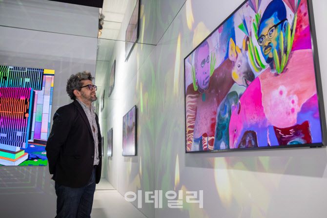 아트 바젤 인 바젤 2025 삼성 아트 스토어 컬렉션에 참여한 바심 매그디가 아트큐브에 전시된 자신의 작품을 감상하고 있다.(사진=삼성전자)