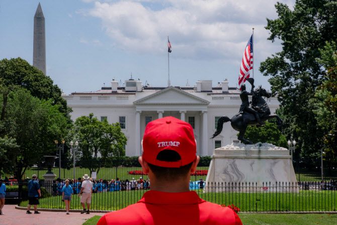 도널드 트럼프 미국 대통령 지지자가 19일(현지시간)미국 워싱턴 D.C. 노스 론 스탠드에 설치된 새로운 깃대를 바라보며 백악관을 바라보고 있다.(사진=로이터)