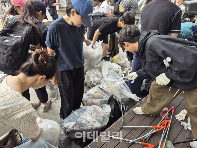 지난 21일 오전 서울 관악구 신림 일대에서 자발적으로 모인 시민들이 하수구를 청소하고 모은 쓰레기들을 종량제봉투에 정리하고 있다. (사진=정윤지 기자)