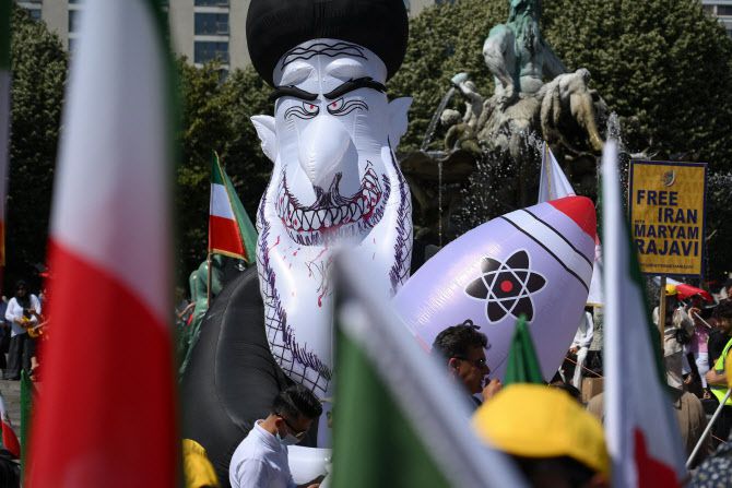 21일(현지시간) 독일 베를린에서 시위대들이 이란 최고 지도자 아야톨라 알리 하메네이와 핵폭탄 모양의 풍선을 들고 시위를 벌이고 있다.(사진=AFP)
