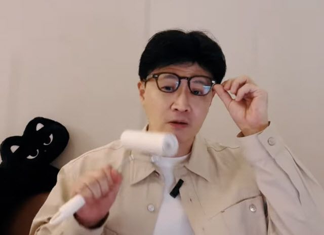 한동훈 전 국민의힘 대표가 라이브 방송에서 돌돌이 얼굴에 묻은 고양이 털을 떼고 있는 모습.  (사진=유튜브 캡처)