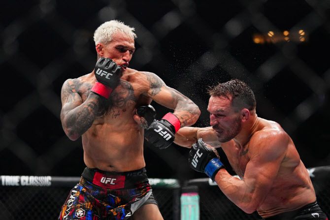 마이클 챈들러(오른쪽)를 무너뜨리는 찰스 올리베이라. 사진=UFC