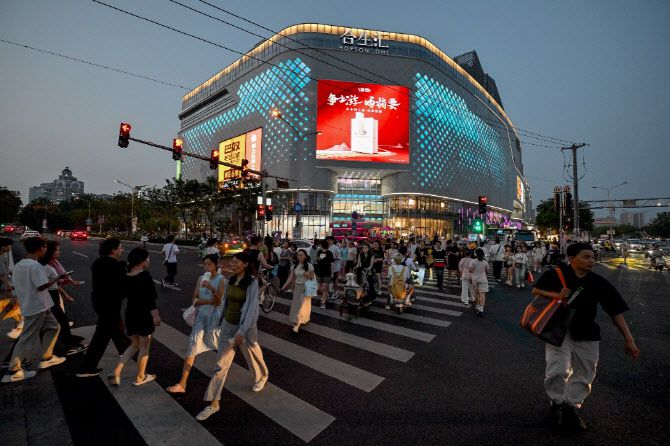 중국 베이징의 한 쇼핑몰 앞을 시민들이 지나가고 있다. (사진=AFP)