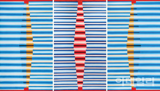 이승조의 ‘핵 G-999’(1970). 세 개의 캔버스를 연결해 한 작품으로 구성했다. 후기로 갈수록 사라져간, 적·청 등 원색을 들인 드문 작업이기도 하다. 푸른 원통의 규칙적인 반복이 꿈틀거리는 율동미를 만들고 있다. 일생동안 놓지 않은 ‘파이프’ 형상을 두고 작가는 기차여행 중 망막에 얼핏 스치는 강렬한 인상을 담아냈다고 그 처음을 설명한 적이 있다. “미묘한 감동에 휩싸여 이틀 밤을 꼬박 새우며 마음에 남은 이미지를 조작해 완성했다”고 했다. 캔버스에 유화 물감, 194×112×(2), 192×111㎝. 국립현대미술관 소장.