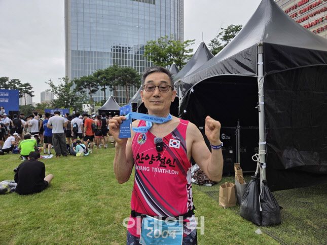 6일 ‘2025 롯데 아쿠아슬론’에 참가한  박종섭 씨(74)가 완주 메달을 들어 보이며 포즈를 취하고 있다. 박 씨는 이번 대회 최고령 참가자로 완주에 성공했다. (사진=한전진 기자)