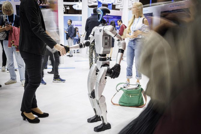 지난 8일 스위스 제네바에서 열린 글로벌 서밋에서 유니트리의 휴머노이드 로봇이 방문객들과 인사하고 있다. (사진=AFP)