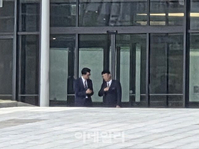 정장을 갖춰 입은 인사들이 롯데인재개발원 본관 로비 앞에서 대화를 나누고 있다. 회의 시작 시각조차 비공개로 진행된 이번 VCM은 철저한 통제 속에 열렸다. (사진=한전진 기자)