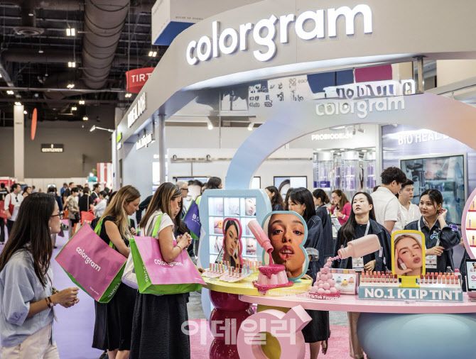 지난 16일 미국 라스베이거스 코스모프로프 현장에서 올리브영 부스를 방문한 미국 바이어들이 K뷰티 제품을 살펴보고 있다. (사진=올리브영)