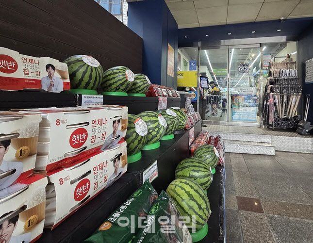 신림역 인근 한 편의점 입구에 수박, 햇반, 계란 등 생필품과 제철 과일이 전면 진열돼 있다. 민생쿠폰 지급 이후 식재료 수요가 늘며 고가 품목까지 매대 구성에 포함되고 있다. (사진=한전진 기자)
