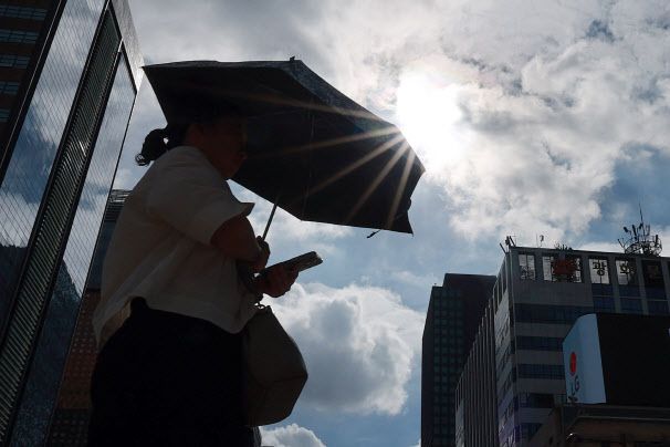 절기상 가장 더운 대서(大暑)인 22일 서울 세종대로사거리에서 양산을 쓴 시민이 횡단보도를 건너고 있다.(사진= 연합뉴스)