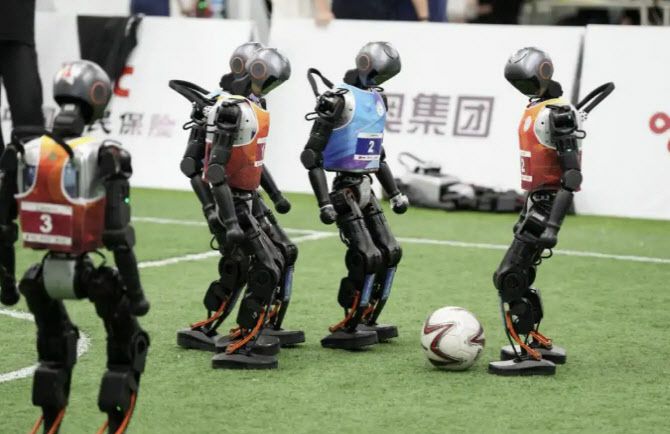 지난 13일 중국 베이징 빙상경기장에서 로봇 게임 출전을 앞둔 휴머노이드 로봇들이 축구를 하고 있다. (사진=바이두)