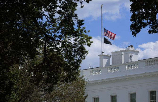 도널드 트럼프 미국 대통령이 27일(현지시간) 미네소타주 미니애폴리스의 총기난사 사건 희생자를 추모하기 위해 모든 공공건물에 조기 게양을 지시하는 포고문을 발표한 뒤 백악관이 국기를 내려 단 모습. (사진=AFP)