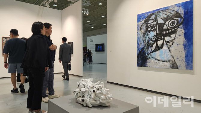 ‘프리즈 서울 2025’ 전경. 스프루스 마커스가 내건 조지 콘도의 ‘생각과 미소’(Thinking and Smiling, 2025). 관람객들의 발길을 연이어 이끈 작품이다. 180만달러(약 25억원)에 팔렸다. 아래는 로즈마리 트로켈의 조각 ‘화장지가 있어 천만다행’(Thank God for Toilet Paper, 2008)이 놓였다(사진=오현주 문화전문기자).