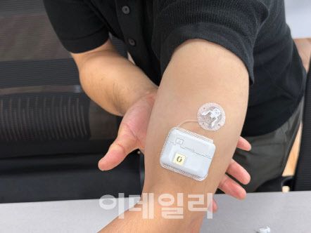 큐어스트림 직원이 패치 디바이스 착용 모습을 시연하고 있다.(사진=임정요 기자)