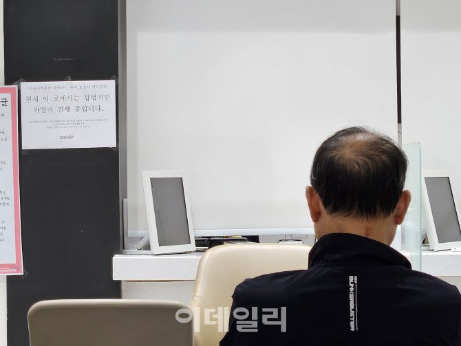 24일 오전 병원 진료 업무 시작 전 서울대병원 본관에서 한 환자가 대기하는 모습. 환자 옆에 노조 파업 안내문이 붙어 있다.(사진=안치영 기자)