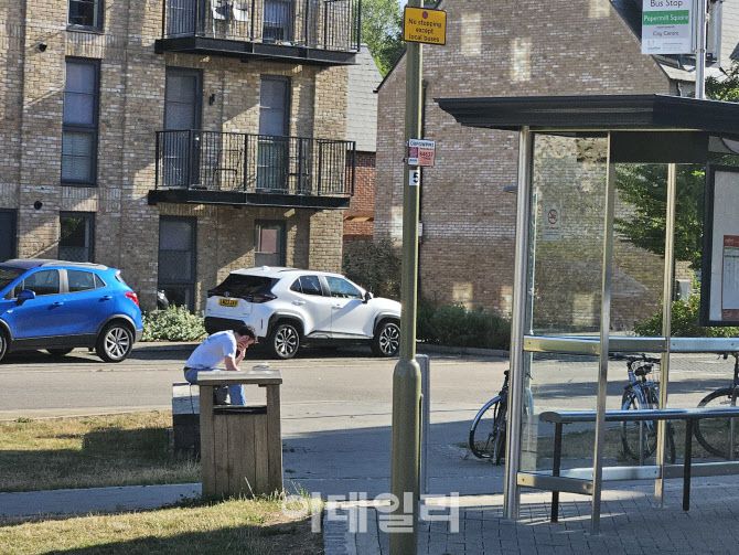런던 교외에서 한 청년이 책을 보며 버스를 기다리고 있다. 영국 내에서 스마트폰을 통해 인터넷 사용률은 늘었지만, 일부 지역과 특정 장소에서는 인터넷 사용이 어려워 아직도 책을 읽는 인구가 많은 편이다. (사진=안치영 기자)