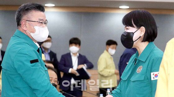 전현희 전 국민권익위원장이 2022년 9월 정부서울청사에서 열린 을지연습 사후 강평회의에서 유병호 당시 감사원 사무총장 자리로 찾아가 악수를 하고 있다. [뉴스1 제공]