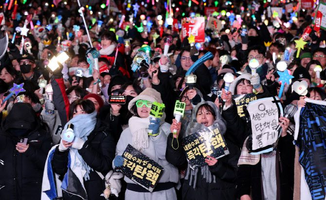지난해 서울 여의도 국회의사당 앞에서 열린 윤석열 즉각 탄핵 범국민 촛불대행진에 참여한 시민들이 윤석열 전 대통령에 대한 탄핵소추안이 가결된 후 환호하고 있다(사진=방인권 기자).