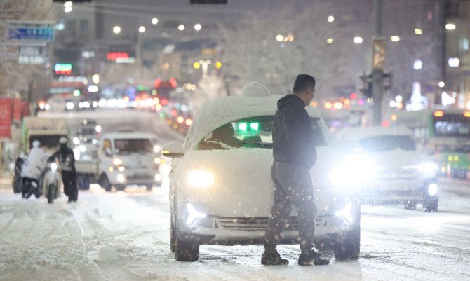 서울·인천·경기·강원 등 4개 시도에 대설특보가 발효된 4일 서울 마포구 홍대 인근에서 제설작업이 완료되지 못한 언덕길을 지나던 택시가 눈길에 멈춰 서있다. (사진=연합뉴스)