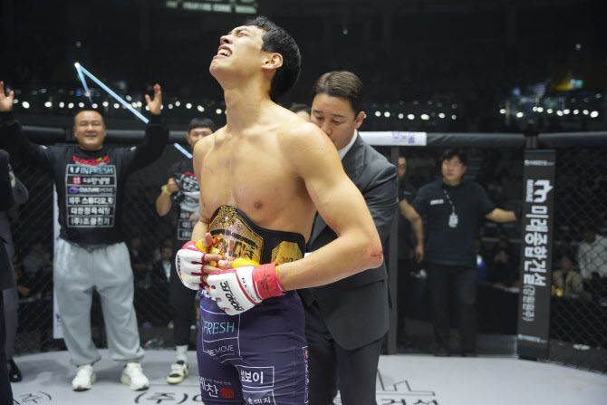로드FC 초대 웰터급 챔피언에 오른 윤태영에게 정문홍 로드FC 대표가 챔피언 벨트를 채워주고 있다. 사진=로드FC