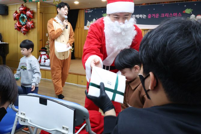 홍범식 LG유플러스 사장이 희망산타로 변신해 어린이에게 선물을 전달하는 모습. 사진=LG유플러스
