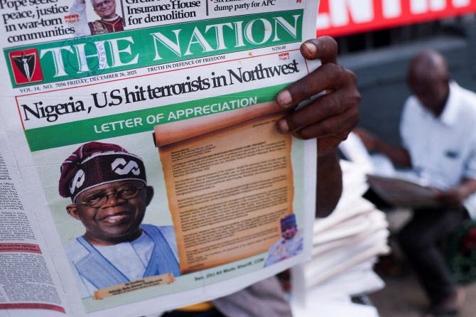 미국이 지난 25일(현지시간) 나이지리아 내 이슬람국가(IS) 무장세력을 상대로 공습을 단행한 가운데, 지난 26일 나이지리아 라고스에서 시민들이 관련 소식을 전하는 신문을 읽고 있다. (사진=로이터)