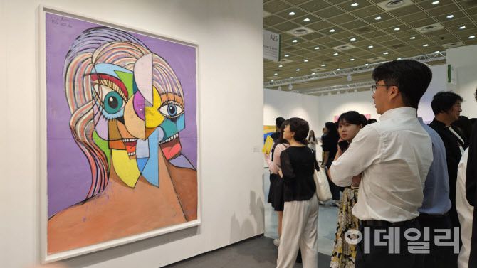 [‘2025년 미술계’ 한 장면⑤] 9월에 열린 ‘2025 키아프리즈’ 중 ‘프리즈 서울’ 전경. 한 관람객이 하우저앤워스 부스에 걸린 조지 콘도의 ‘퍼플 선샤인’(Purple Shunshine, 2025)을 오래도록 지켜봤다. 이 작품은 120만달러(약 16억 7000만원)에 판매됐다(사진=오현주 문화전문기자).