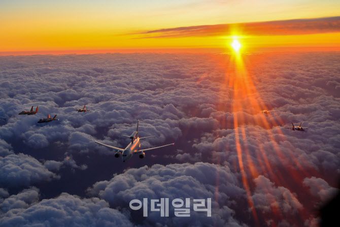 1일 오전 안규백 국방부 장관이 탑승한 ‘하늘의 지휘소’ 공군 항공통제기(E-737 / 가운데)가 떠오르는 태양 아래 KF-21 등 국산 전투기 편대의 엄호를 받으며 비행하고 있다. (사진=국방부)