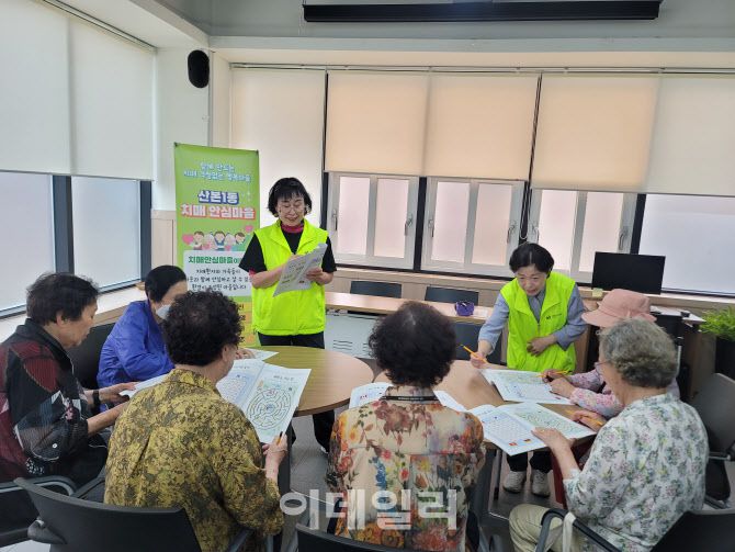 군포시 내 한 커뮤니티센터에서 녹색 조끼를 입은 ‘치매서포터즈’가 어르신을 대상으로 ‘가치함께 돌봄교실’을 진행하고 있는 모습.(사진=군포시 치매안심센터)