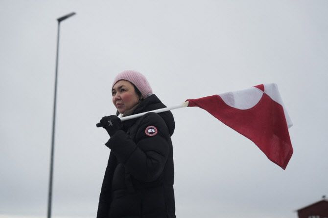 17일(현지시간) 그린란드 누크에서 미국 대통령의 그린란드 인수 계획에 반대하는 시위가 열리는 가운데, 한 여성이 그린란드 국기를 들고 있다. (사진=AFP)