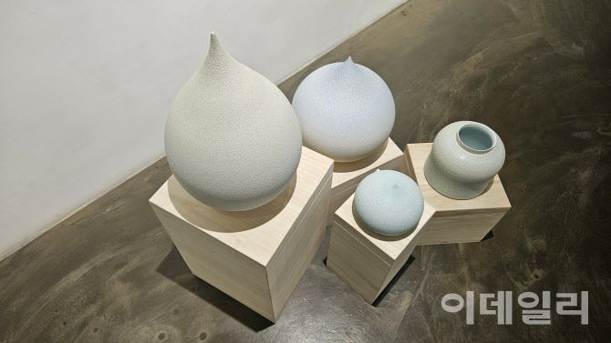 갤러리조은 ‘평온의 가장자리’ 전 전경. 바닥에 설치한 조원재의 ‘물방울’ 연작과 항아리 작품을 위에서 내려다봤다. ‘순간의 가장자리’(2025), ‘푸른 물방울’(2025) 곁에 ‘2023-푸른호-017’(2023, 21×21×20㎝·오른쪽)가 놓였다(사진=오현주 문화전문기자).