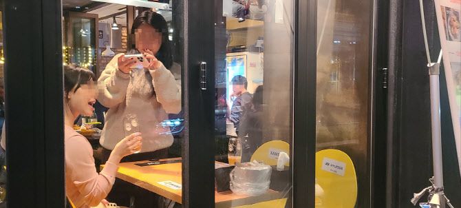 깐부치킨 삼성점을 찾은 관광객들이 젠슨황 테이블에 앉아 기념사진을 찍고 있다.